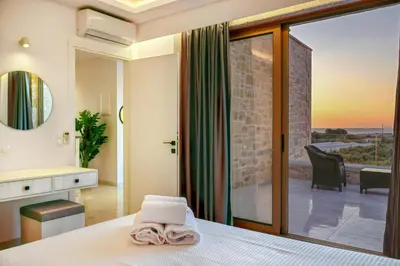 a bedroom with a bed and a view of a patio at Koukis Villa With Sea View in Falasarna