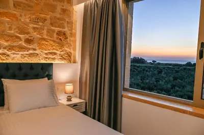 a bedroom with a bed and a window with a view at Koukis Villa With Sea View in Falasarna