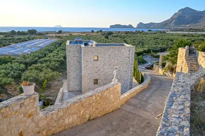 an external view of a building with a stone wall at Koukis Villa With Sea View in Falasarna