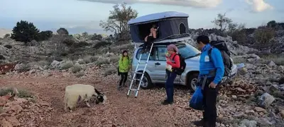a group of people standing next to a van with a sheep at Rooftop Jeep Escape Sleep Under the Stars in Chania Town