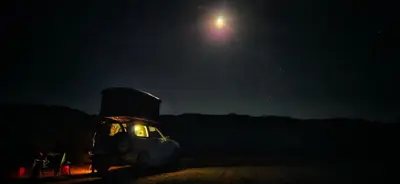 a truck parked in a field at night at Rooftop Jeep Escape Sleep Under the Stars in Chania Town