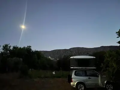a car parked in a field with a camper on top at Rooftop Jeep Escape Sleep Under the Stars in Chania Town
