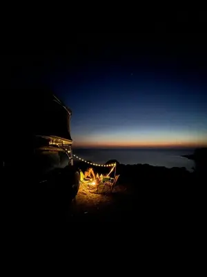 a lit up chair sitting on top of a hill at night at Rooftop Jeep Escape Sleep Under the Stars in Chania Town
