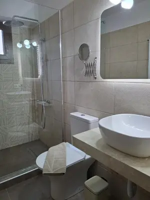 a bathroom with a sink and a toilet and a shower at Terra Solaris Guesthouse in Kissamos