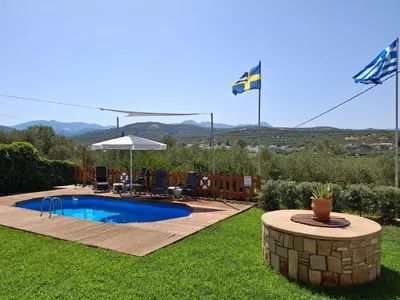 a swimming pool in a yard with a flag at Terra Solaris Guesthouse in Kissamos