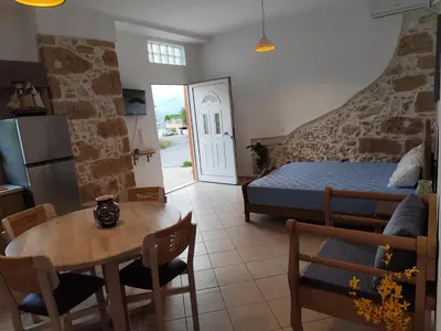a room with a table and a bed and a kitchen at Despoinas House in Plátanos