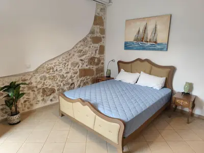 a bedroom with a bed and a painting on the wall at Despoinas House in Plátanos