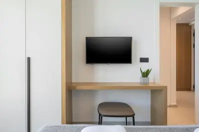 a bedroom with a desk with a television on a wall at Sky Sea View Villas in Chania Town