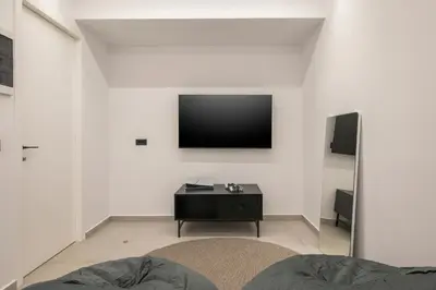 a living room with a tv on a white wall at Sky Sea View Villas in Chania Town