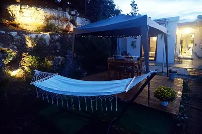 a hammock on top of a deck with a table at Georgia's Dream House in Koprána