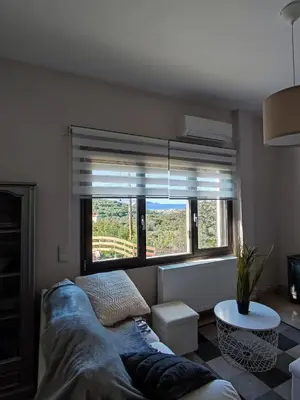 a living room with a couch and a large window at Georgia's Dream House in Koprána