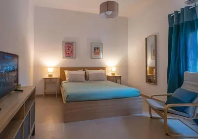 a bedroom with a bed and a tv and a chair at loupagio di mare in Plátanos