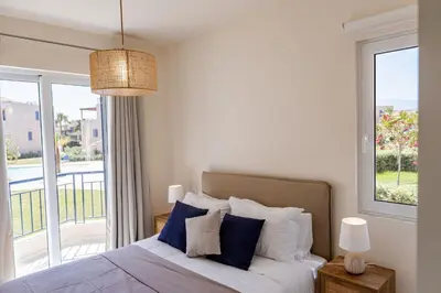 a bedroom with a bed with blue and white pillows at Phaedrus Living Seaside Thalassa Cretan 101 in Módhion