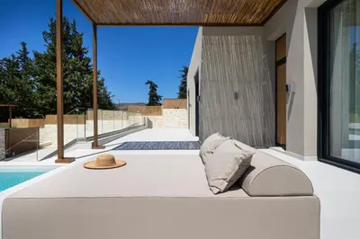 a white couch with a hat on it next to a pool at Elithos Villa in Vryses