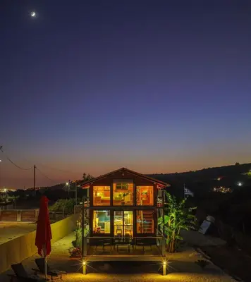 a glass house with lights on it at night at Casa Luma near Loutraki beach in Chania