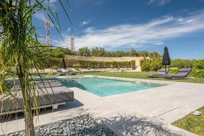 an outdoor swimming pool with chaise lounge chairs next to a yard at Villa Aurora 1- Getaway Bliss in Xamoudhokhórion