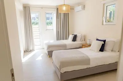 two beds in a white room with a window at Phaedrus Living Seaside Thalassa Cretan 102 in Módhion