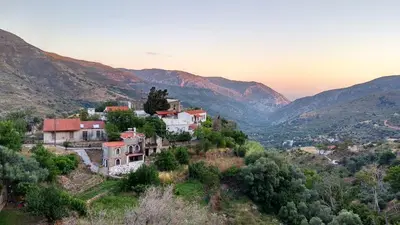 a village on a hill with mountains in the background at Panorama Apartment in Kefálion