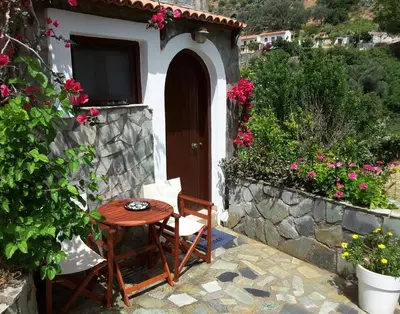 a table and a chair in front of a house at Panorama Apartment in Kefálion