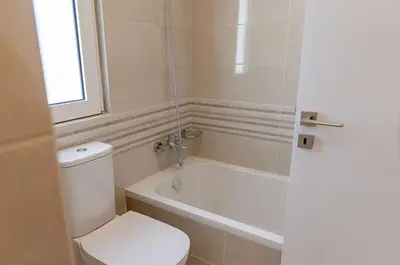 a bathroom with a toilet and a tub and a sink at Phaedrus Living Seaside Thalassa Cretan 103 in Módhion