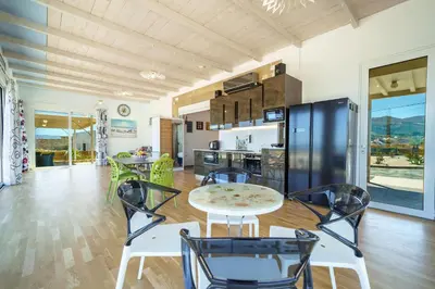 a kitchen and dining room with a table and chairs at Veranda Sul Mare in Gramvousá