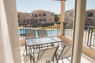 a balcony with a table and chairs and a pool at Phaedrus Living Seaside Thalassa Cretan 202 in Módhion