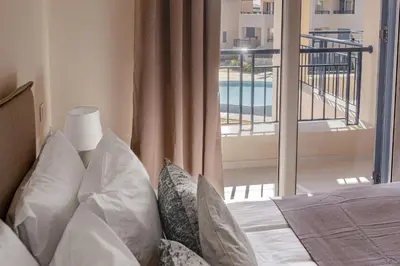 a bedroom with a bed with a view of a balcony at Phaedrus Living Seaside Thalassa Cretan 203 in Módhion