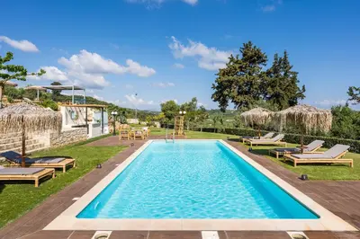 a swimming pool with chaise lounges and chairs in a yard at Luxury Villa Olivenest with Private Heated Pool, Hot Tub & Sauna in Chania Town