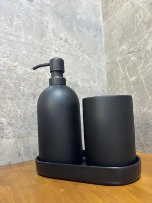 a black soap dispenser sitting on a table at Sofia's Home in Chania Town