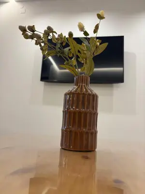 a bronze vase with flowers in it on a table at Sofia's Home in Chania Town