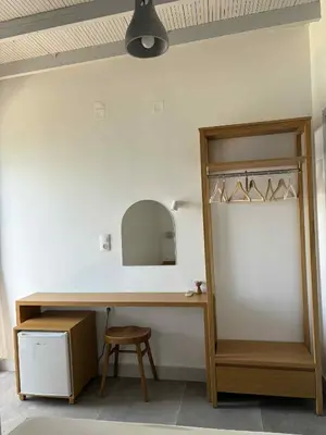 a room with a desk and a mirror and a stool at Nikolas Rooms in Loutro