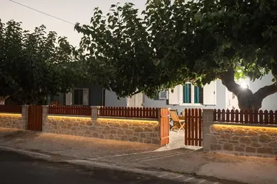 a fence with a tree in front of a building at Arnildi's View in Nopíyia