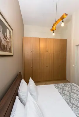 a bedroom with a bed and wooden cabinets at Arnildi's View in Nopíyia