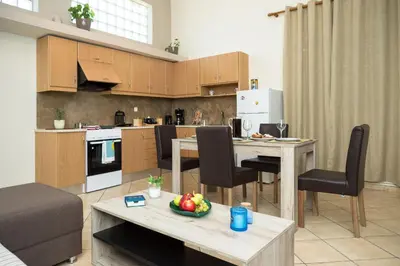 a kitchen and living room with a table and chairs at Arnildi's View in Nopíyia