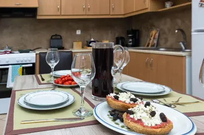 a table with two plates of food and wine glasses at Arnildi's View in Nopíyia