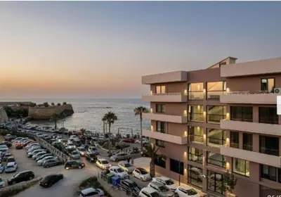 a parking lot with cars parked next to a building at Bay view in town in Chania Town