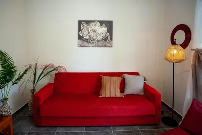 a red couch in a living room with a lamp at Pyrgos Spring pool apartment in Maleme