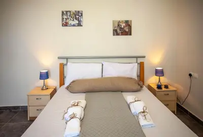 a bedroom with a large bed with two night stands at Pyrgos Spring pool apartment in Maleme