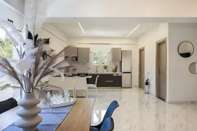 a kitchen and living room with a table and a vase at SI-EL Villa in Vryses