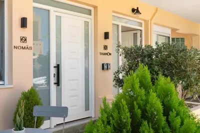 a white door on a house with plants at Thamon lifestyle living in Chania Town