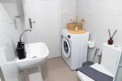 a white bathroom with a washing machine and a sink at Ela Apartment Chania in Chania Town