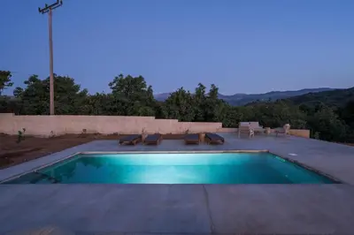 a swimming pool on a patio with chairs at Villa Zen in Alikianós