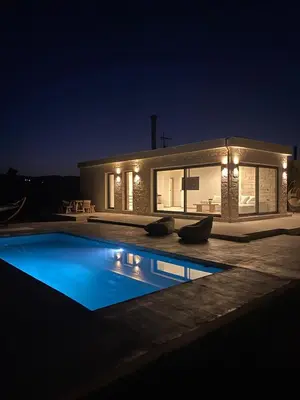 a swimming pool in front of a house at night at Villa Zen in Alikianós