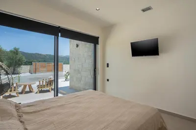 a bedroom with a bed and a flat screen tv at Villa Kumarēs in Alikianós