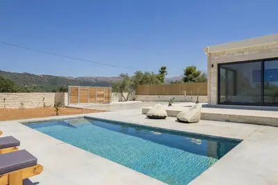 a swimming pool in front of a house at Villa Kumarēs in Alikianós