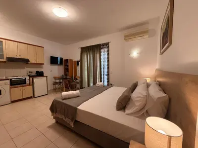 a bedroom with a large bed and a kitchen at Onar-estia in Chania Town