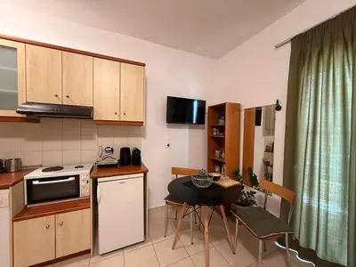 a kitchen with a small table and a small kitchen with a stove at Onar-estia in Chania Town