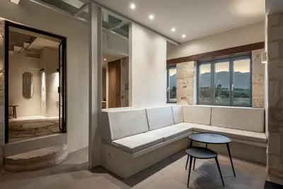 a living room with a white couch and a stool at Olive Hideaway Private Pool Villa, Chania Sleeps 7 in Kalamitsi Amygdali