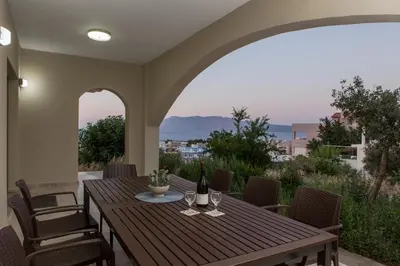 a wooden table with two bottles of wine on a patio at Yume Luxury Home in Pírgos
