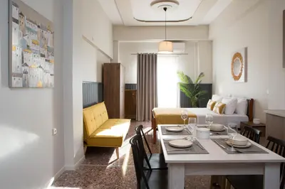a living room with a table and a living room with a bed at Fyllianos Apartments in Plátanos